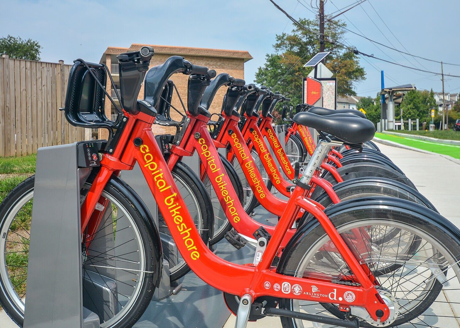 Row of red Capital Bikeshare bikes docked at a station.