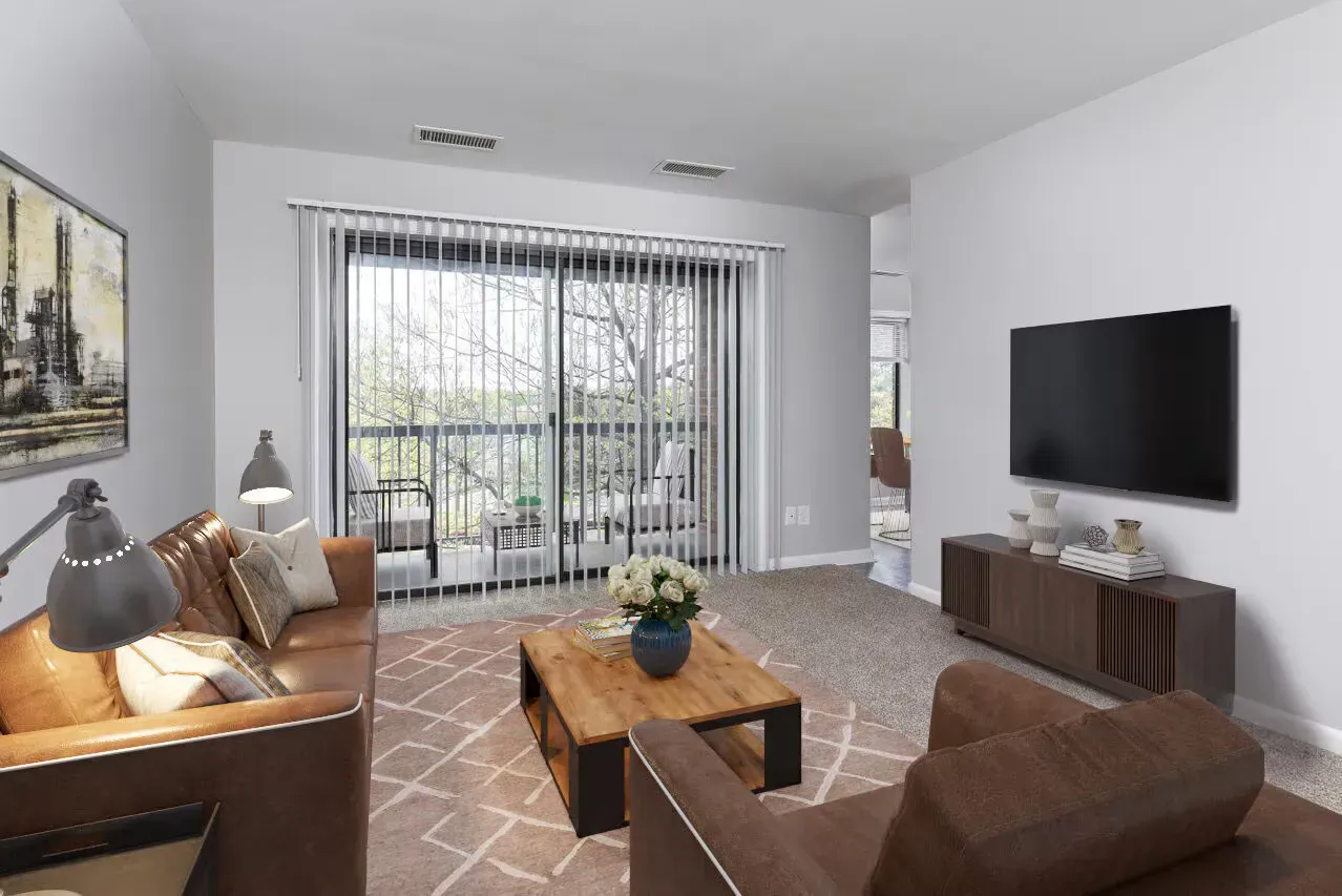 Living room with brown leather sofas, a wooden coffee table, wall-mounted TV, and sliding doors to a balcony.