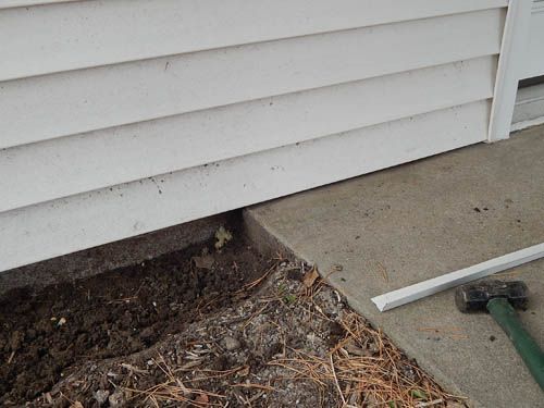 White siding meets a concrete slab