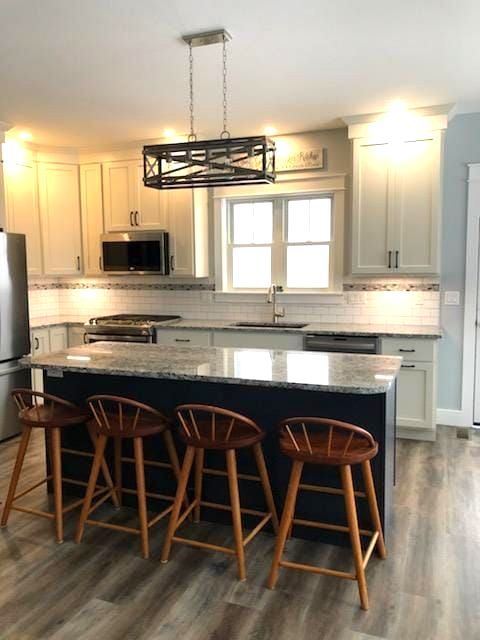 Beautiful kitchen with white cabinets and hanging pendants