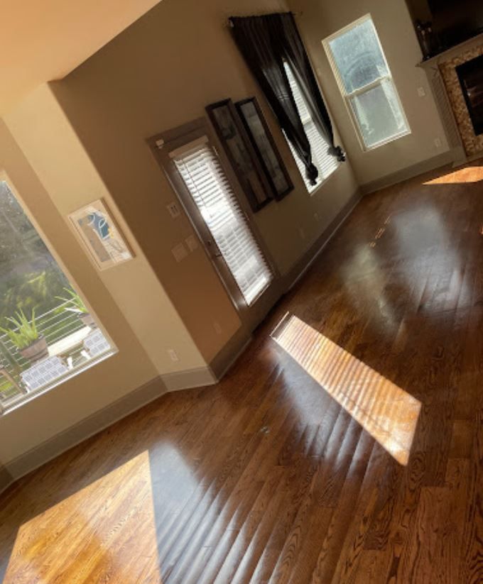 A living room with hardwood floors and lots of windows