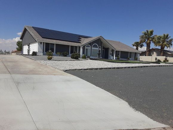 A house with solar panels on the roof and a driveway