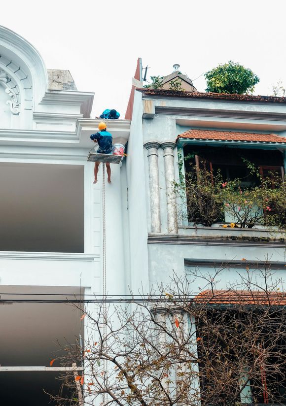 A man is painting the side of a building.
