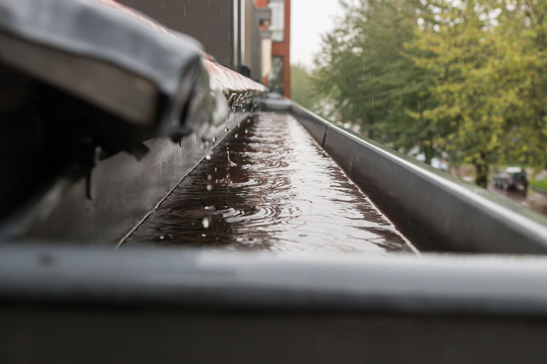 A close up of a gutter with water coming out of it.