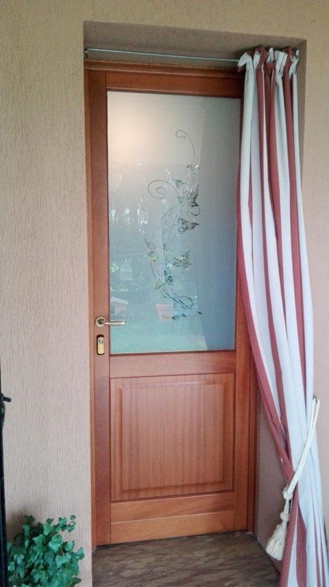 Porta in Meranti lamellare con pannello bugnato e vetro decorato.