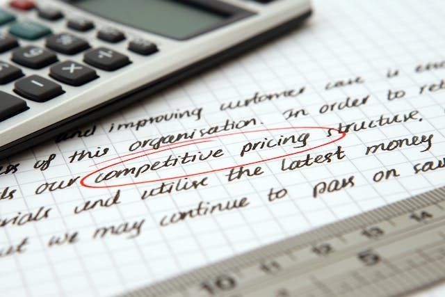 a calculator on a document with the words competitive pricing circled in red