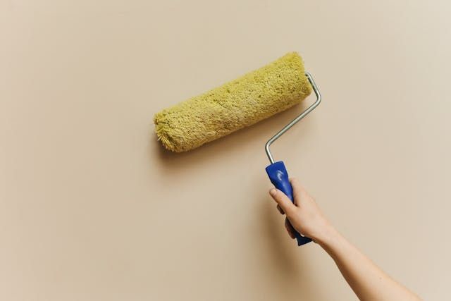 a paint roller on a beige wall