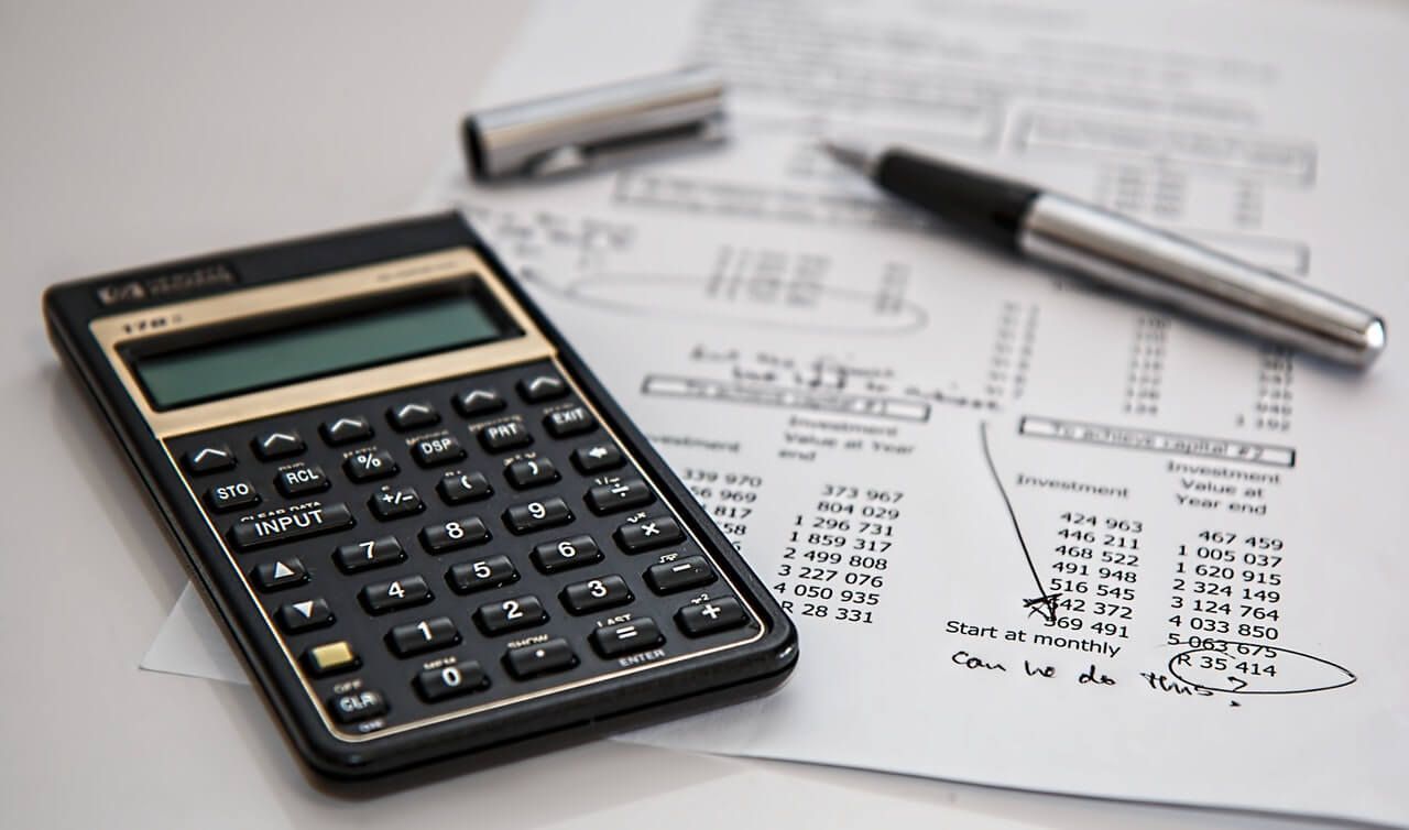 a pen and calculator on a financial breakdown