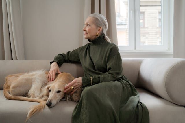 a person sitting on a couch with their dog