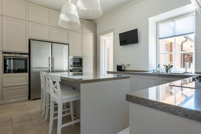 a white modern kitchen with granite counters