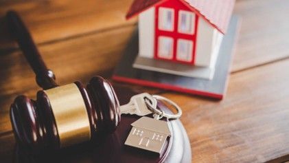 a gavel, house keys, and a home figurine