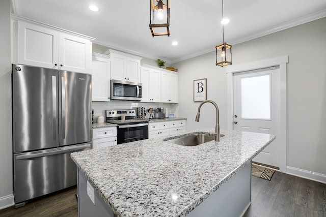kitchen with stainless steel appliances and salt and pepper granite counters