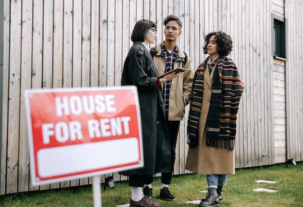 landlord showing two tenants a home for rent during an open house