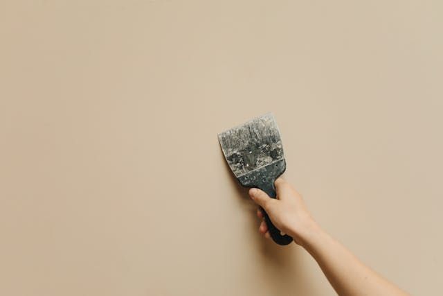 person applying spackle a wall
