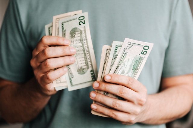 person in a green shirt counting cash