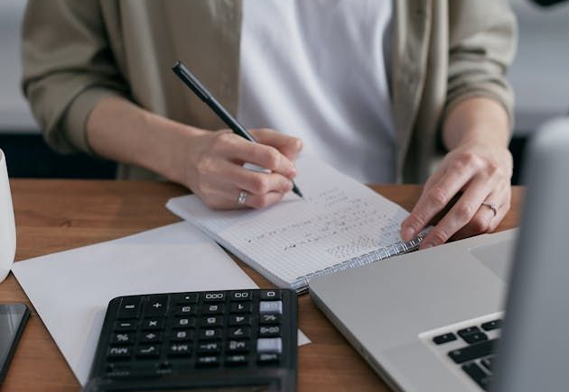 person+using+calculator+and+notepad.
