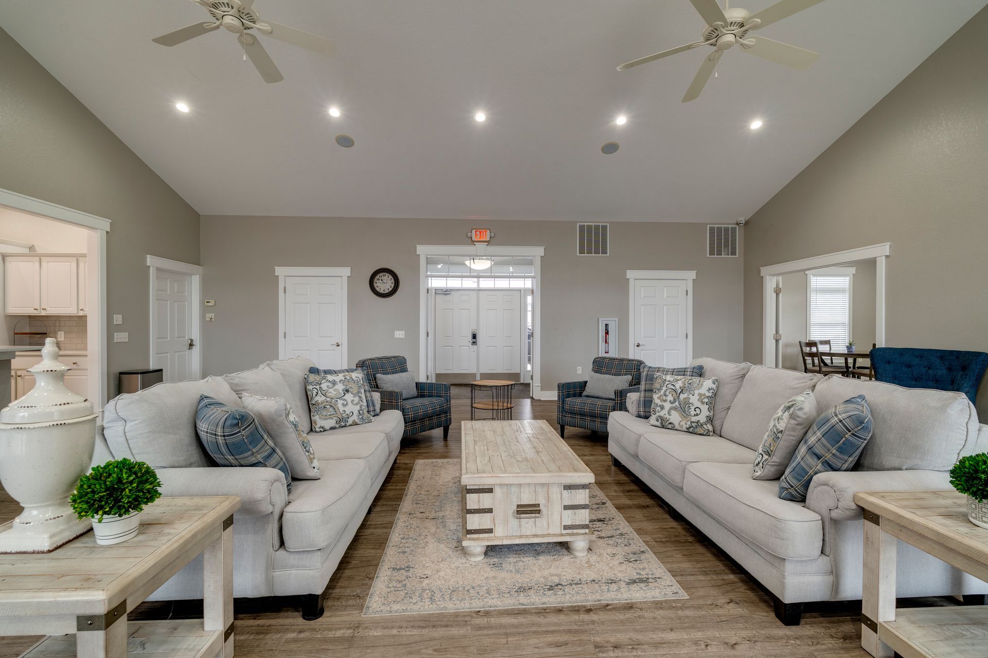 Large living room with two couches, coffee table, and ceiling fans.