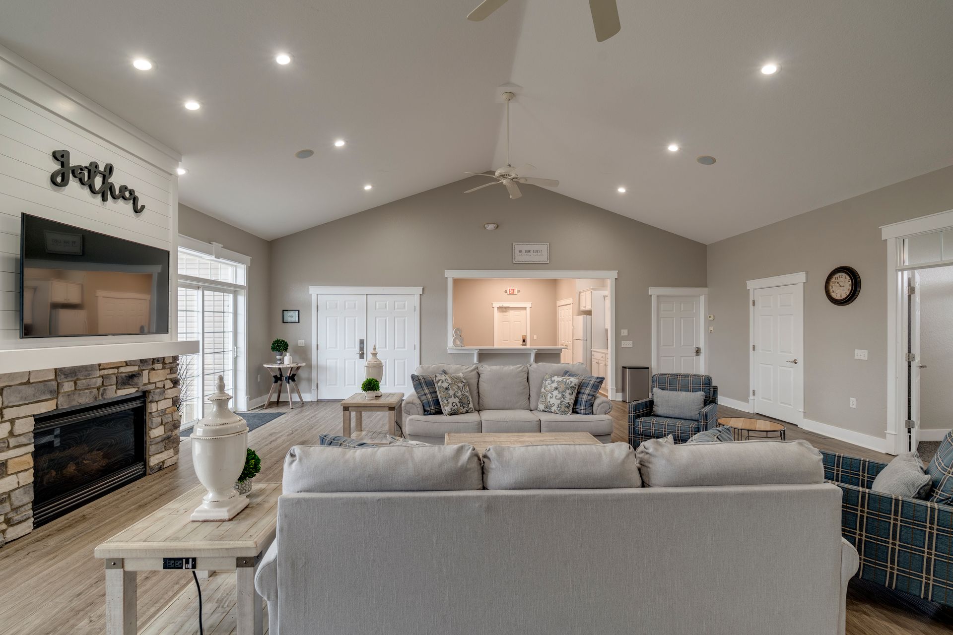 Spacious living room with fireplace, sofas, and recessed lighting, neutral colors.