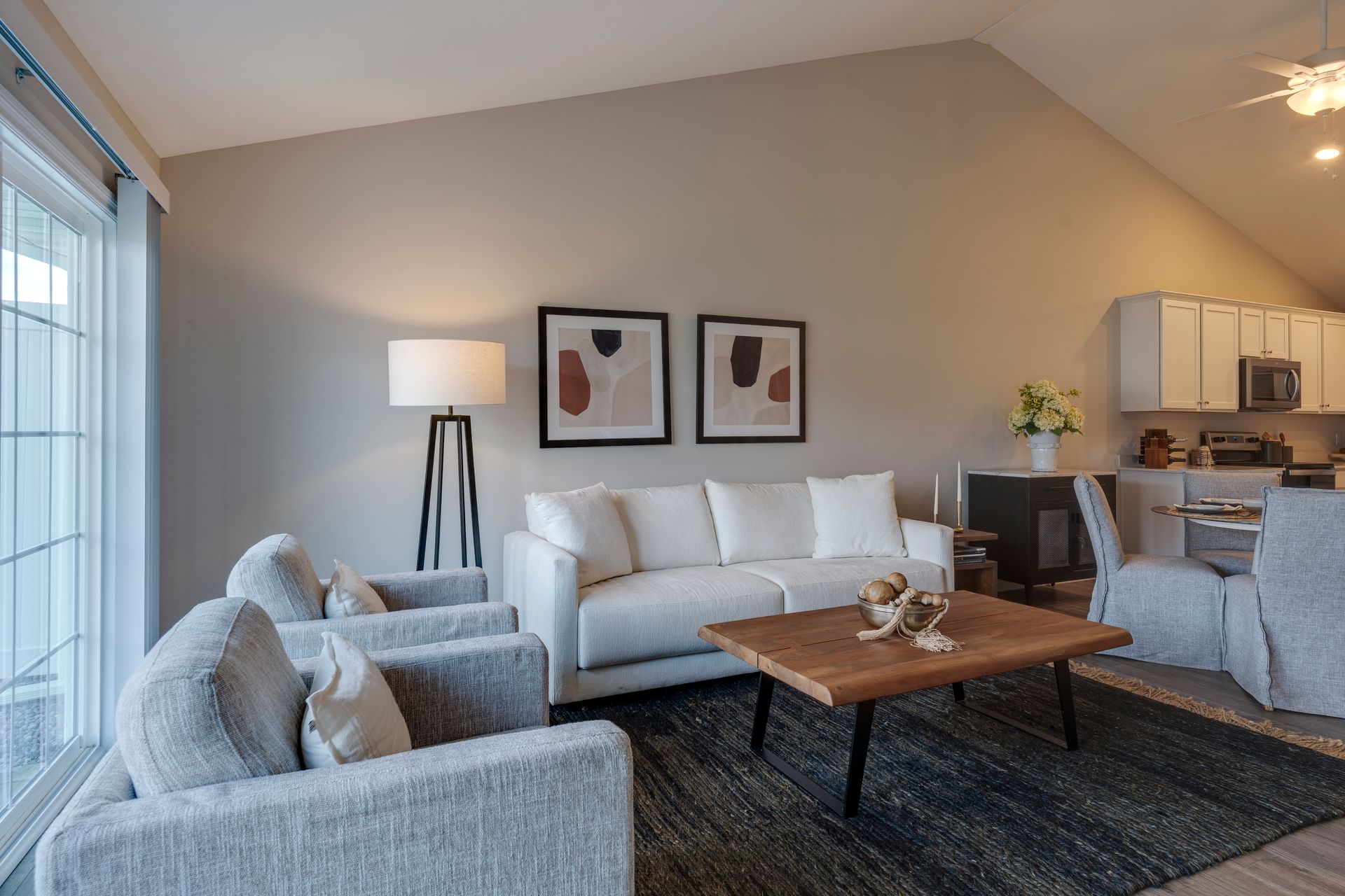 Living room with white sofa, gray armchairs, and wooden coffee table.