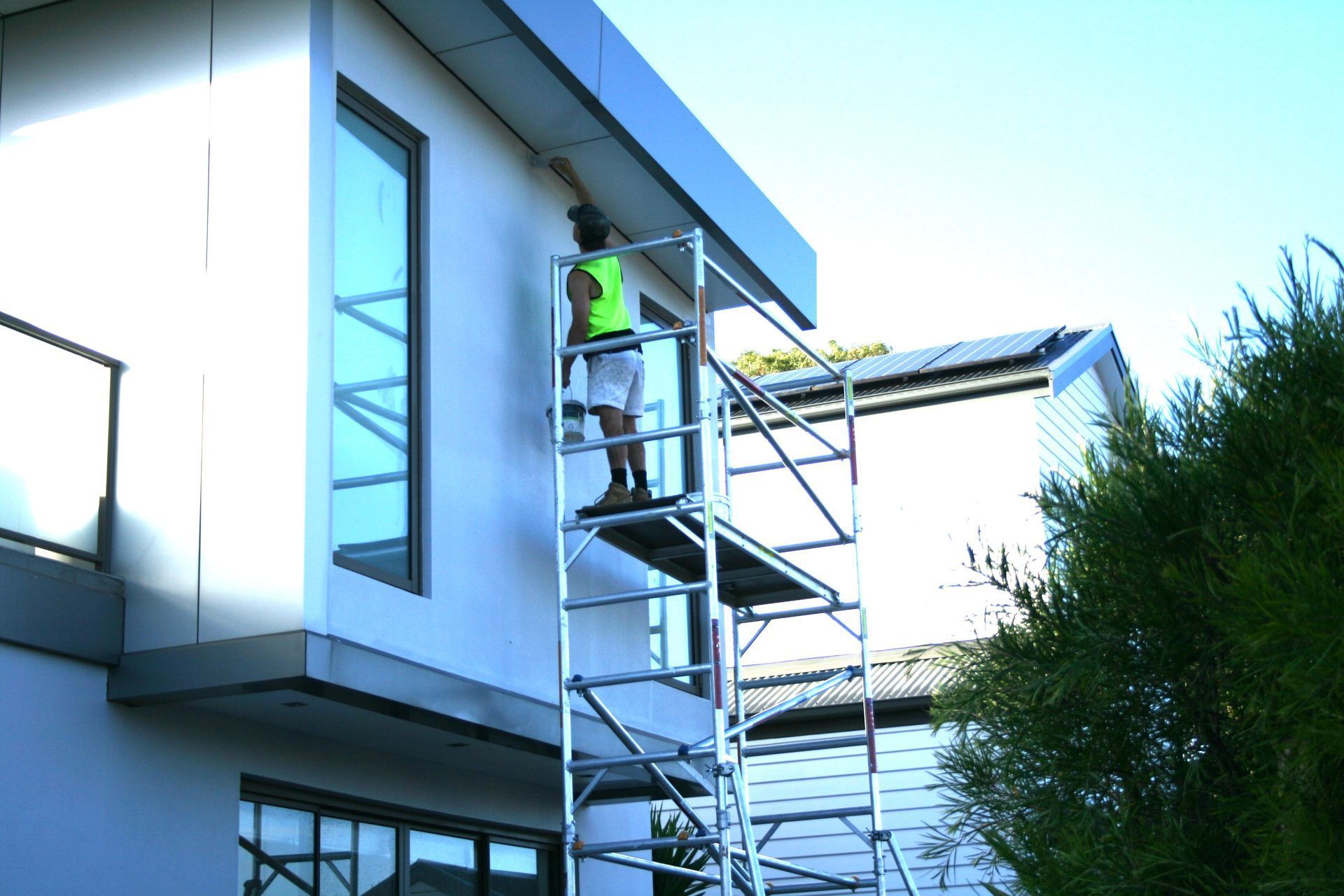 Worker painting house wall