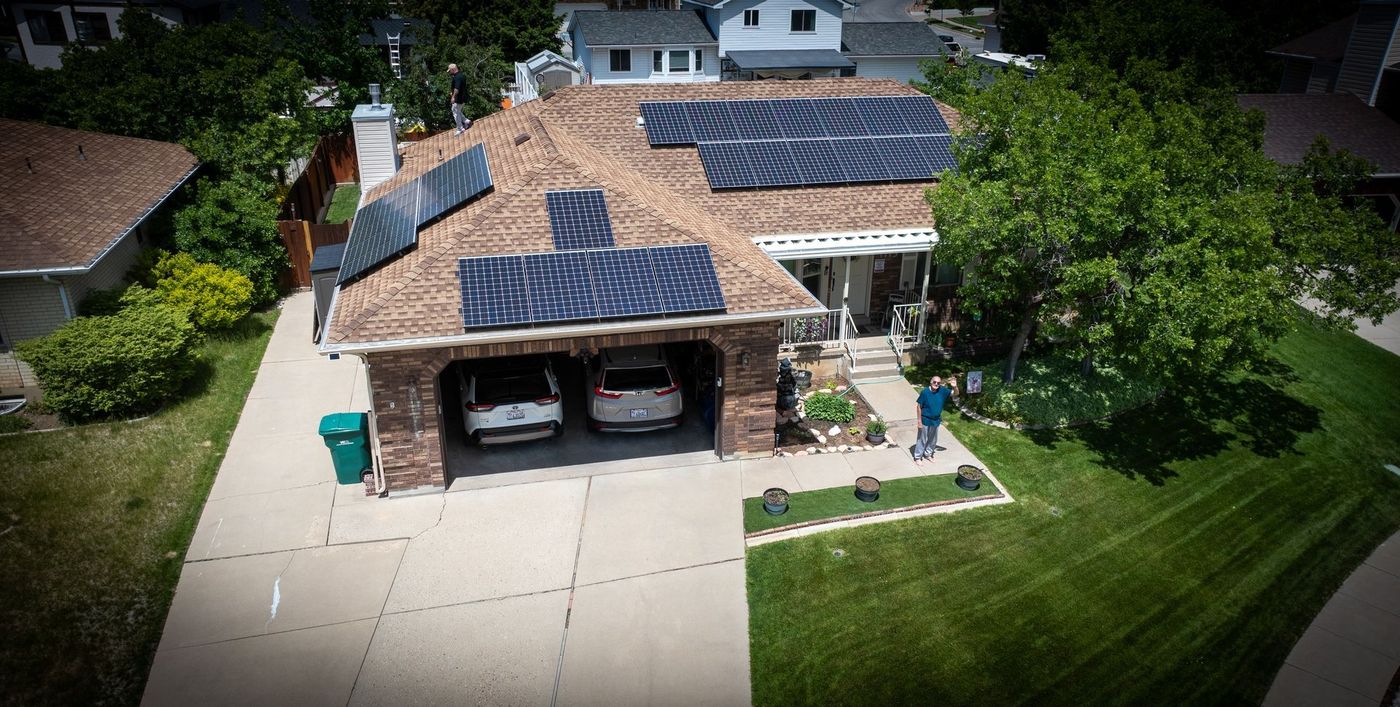 An aerial view of a house with solar panels on the roof.