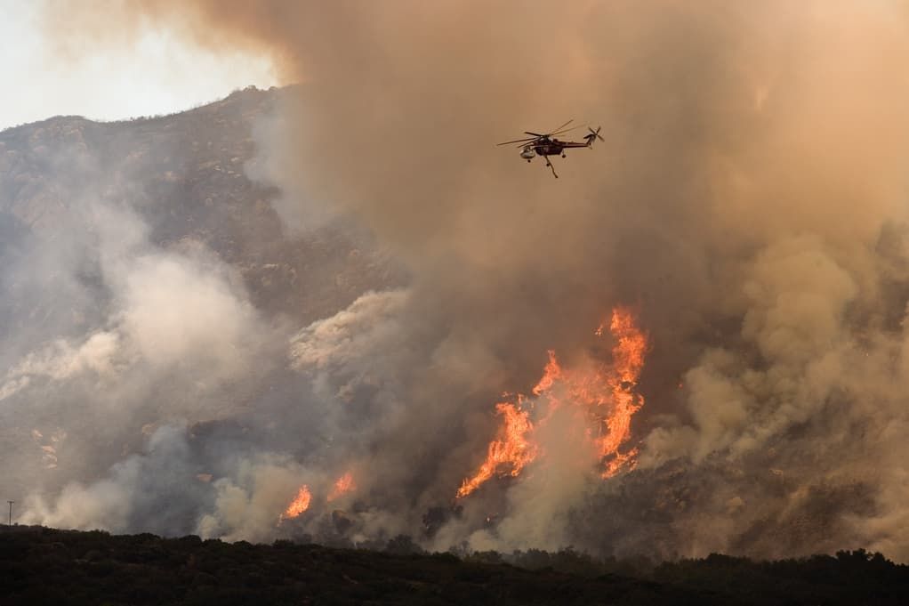 helicopter flying over forest fire