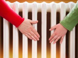 two hands touching a radiator