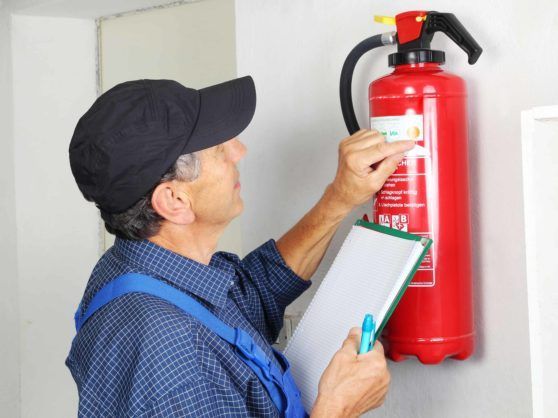 man examining a fire extinguisher