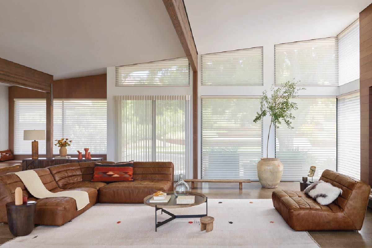 Home living room with many windows dressed with Hunter Douglas blinds featuring PowerView® Automation near Hampton, NH