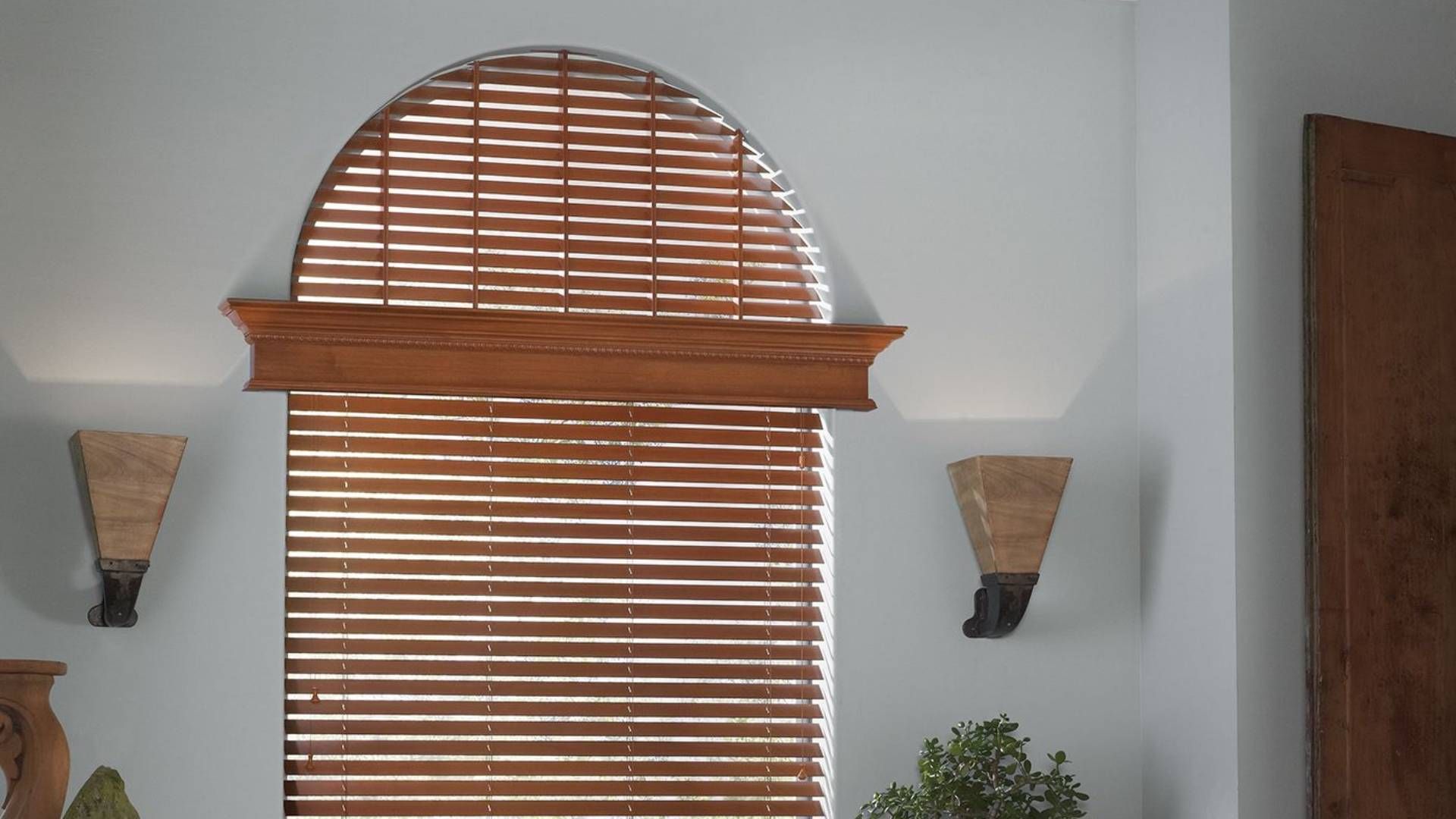 Wooden blinds decorating an arched window in a modern home at Alton Bay Blinds near Hampton, NH