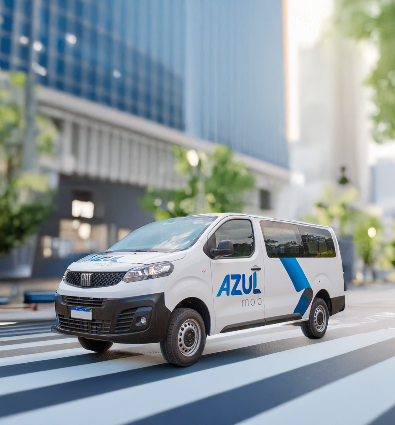 Uma van branca da Azul circulando em uma rua da cidade, com o logotipo da Azul na lateral.