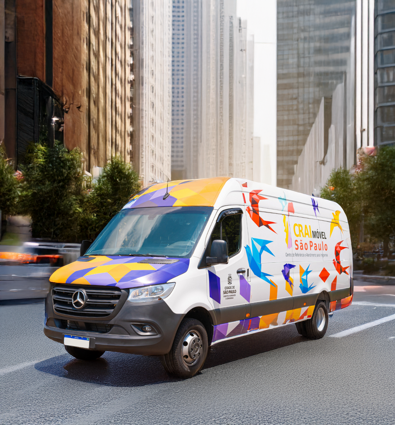 Uma van branca com desenhos geométricos coloridos e em forma de pássaro circulando em uma rua da cidade.