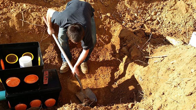 Guy digging hole to septic tank - First Choice Septic in Strasburg, VA