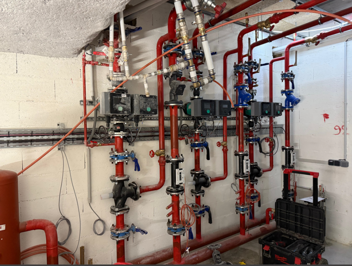 Une pièce remplie de nombreux tuyaux et vannes