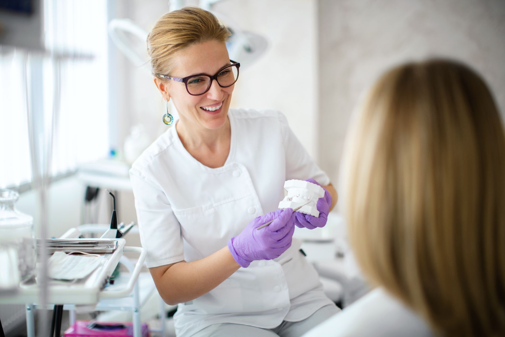 Dentist showing dental plaster mold to the patient.
