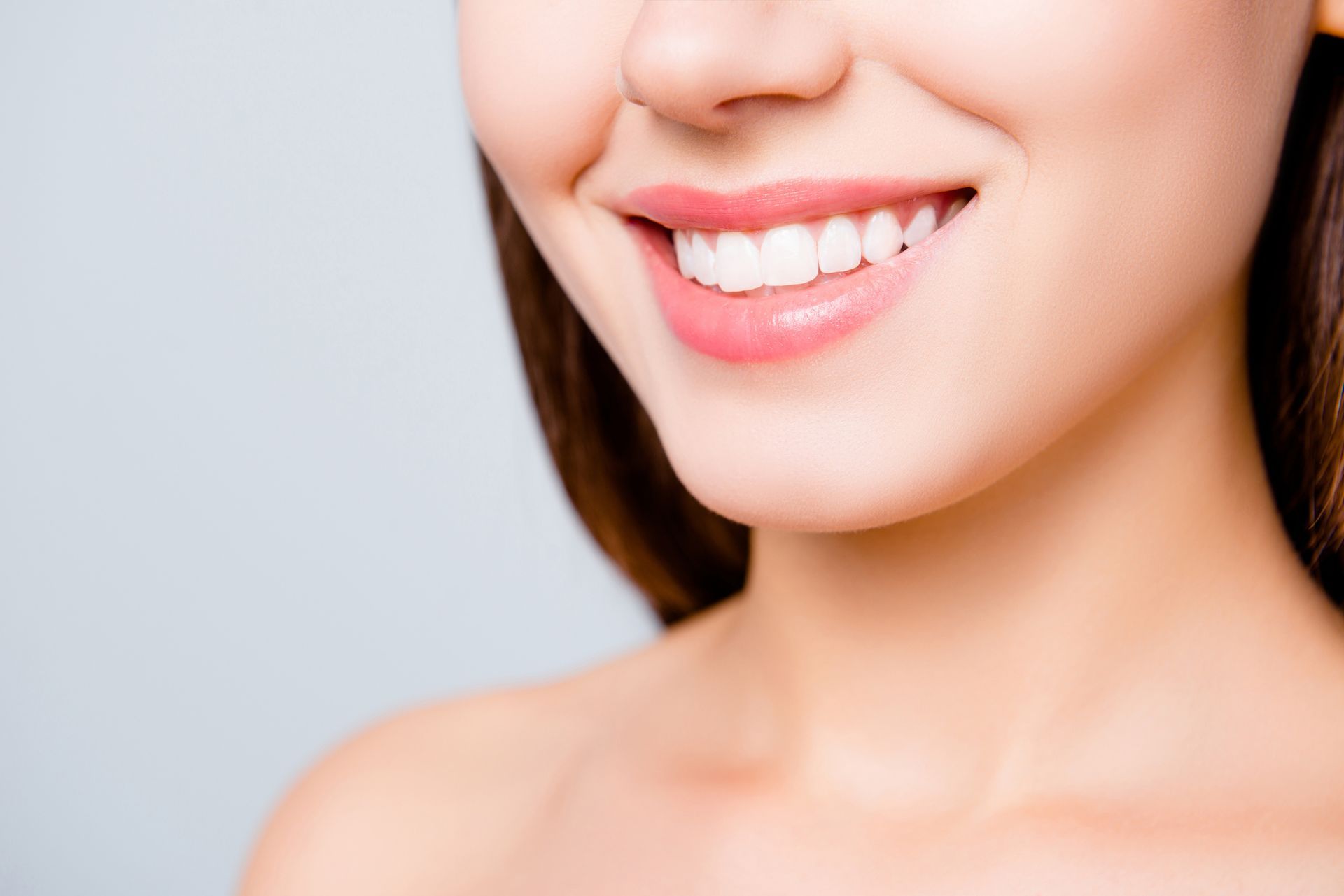 Beautiful young woman smile showcasing cosmetic teeth whitening results.