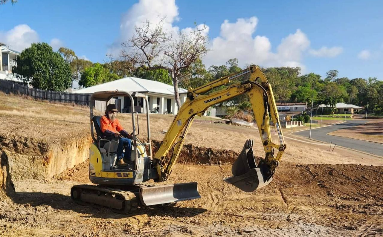 Yellow Front-end Loader Scoops Sand From a Pile — DJ Brazil Pty Ltd in Collinsville, QLD