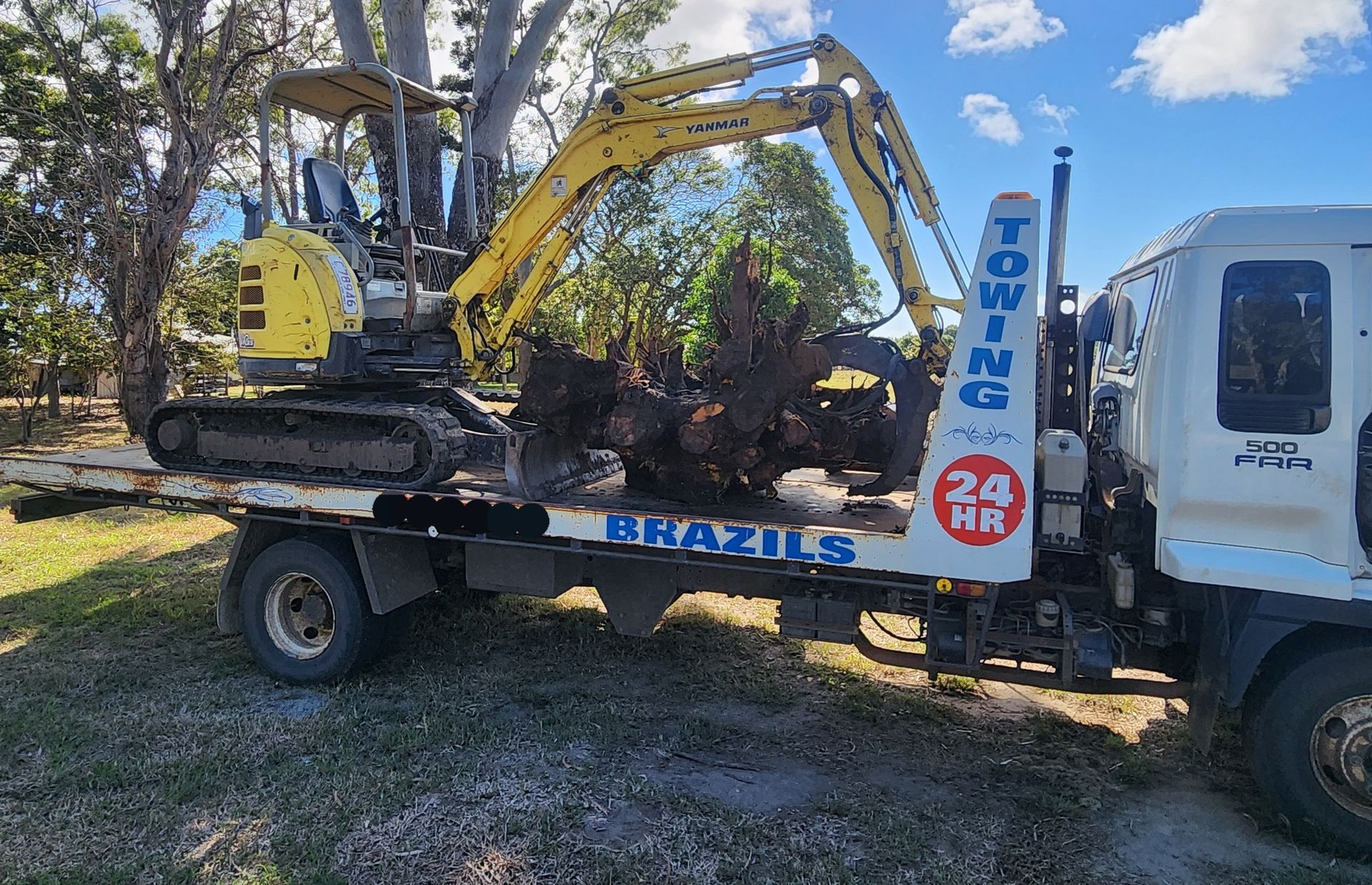 Yellow Excavator on a Tow Truck, Loading Debris — DJ Brazil Pty Ltd in Bowen, QLD