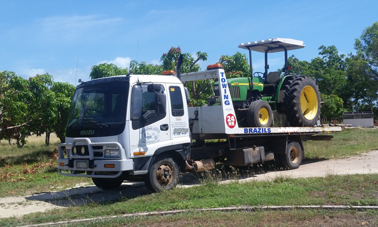 White Tow Truck Carrying a Green John Deere — DJ Brazil Pty Ltd in Bowen, QLD