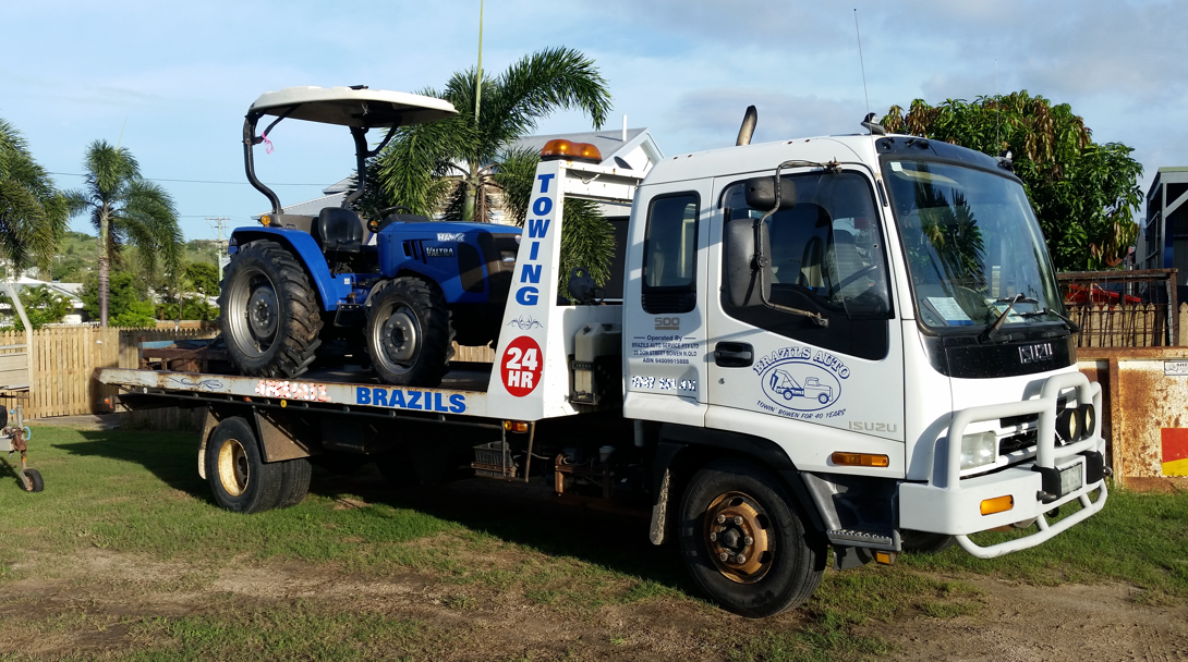 Towing Truck With Blue Tractor on Its Flatbed — DJ Brazil Pty Ltd in Bowen, QLD