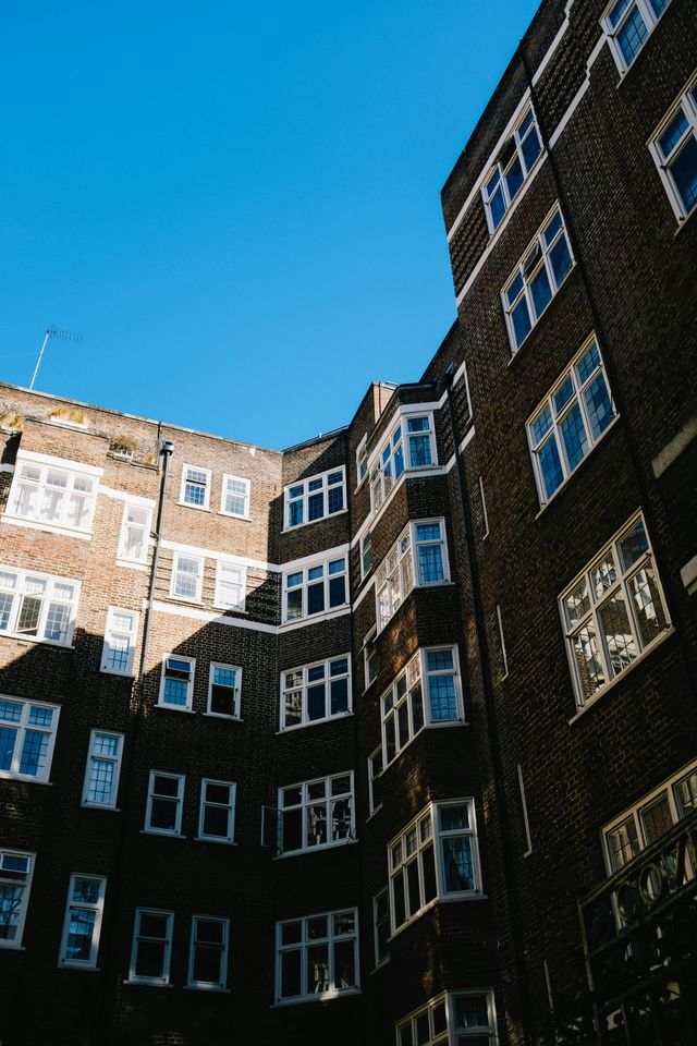 A brick building with a lot of windows and a blue sky in the background.