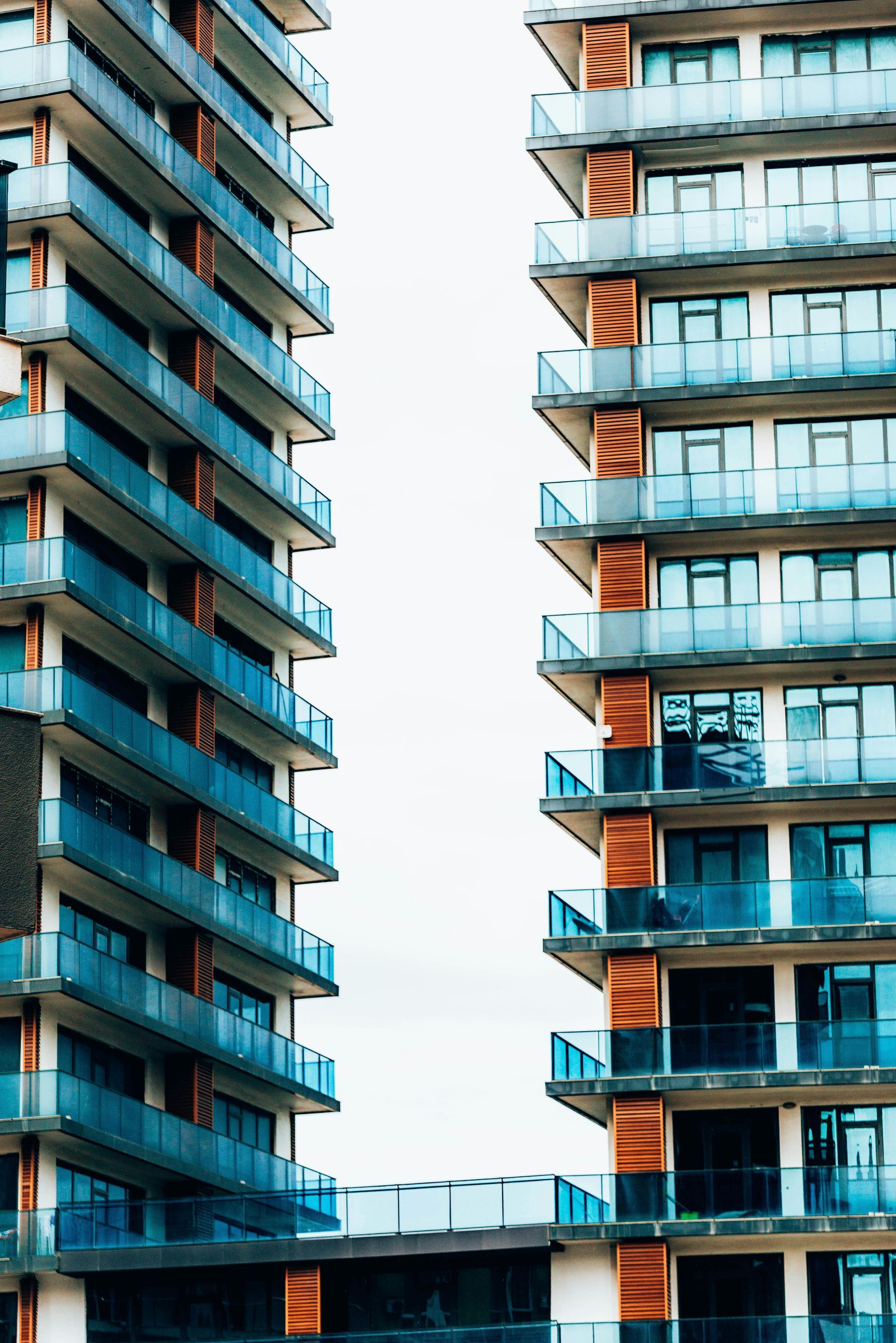 Two tall buildings with blue balconies on a white background.