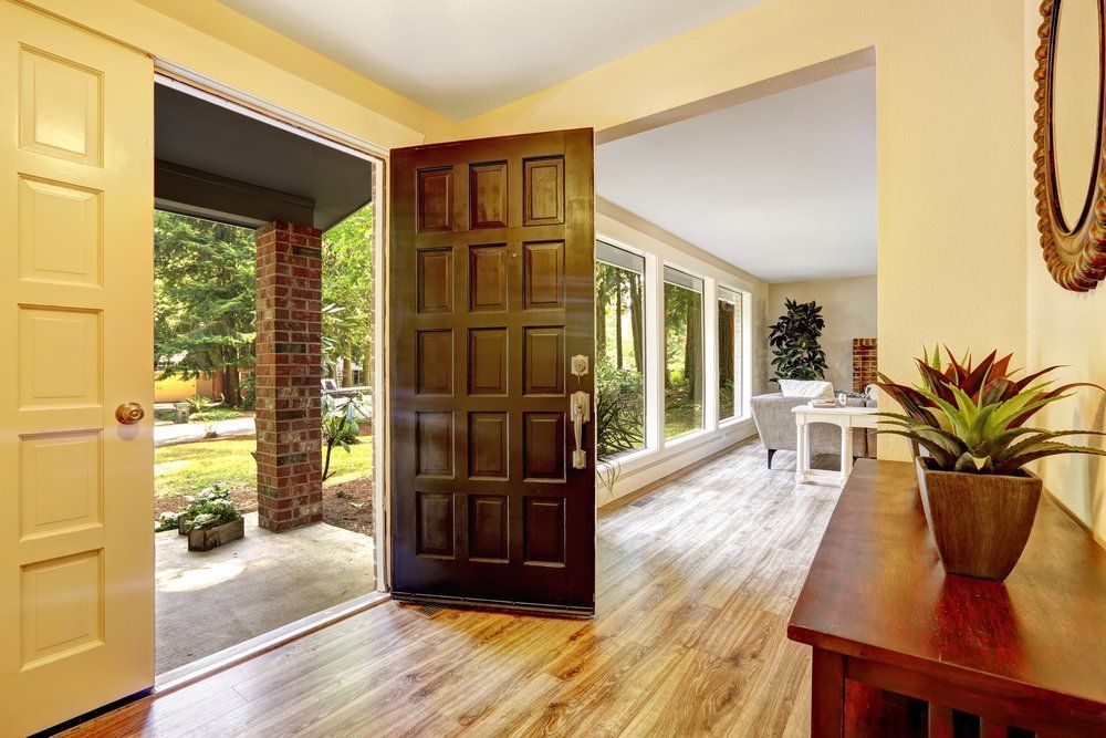 A Hallway in a House With a Wooden Door and Hardwood Floors — Border Pest Control In Albury, NSW
