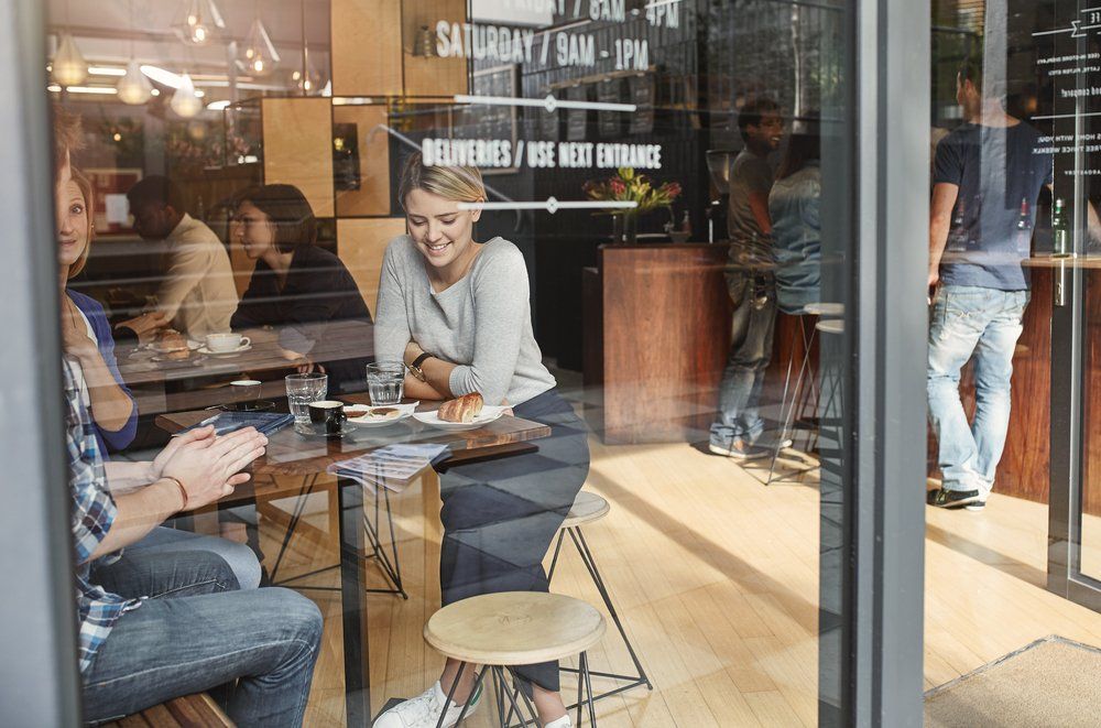 A Group of People Are Sitting at Tables in a Restaurant — Border Pest Control In Albury, NSW