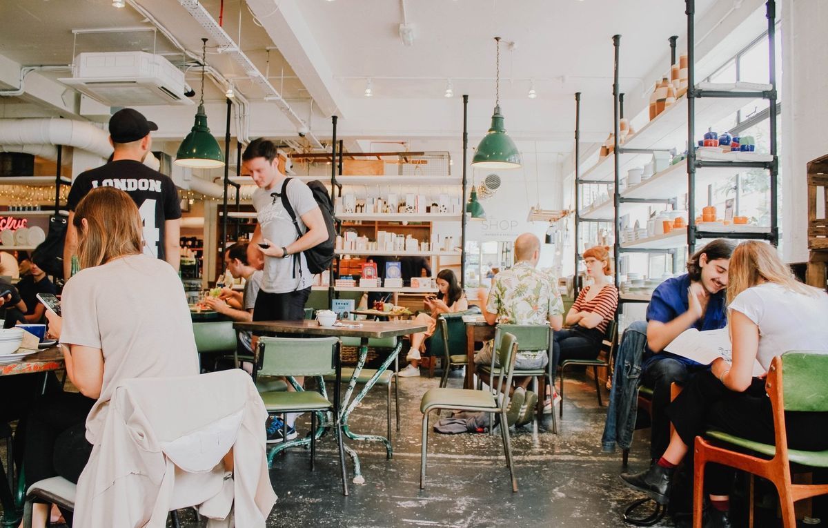 A Group of People Are Sitting at Tables in a Restaurant — Border Pest Control In Albury, NSW