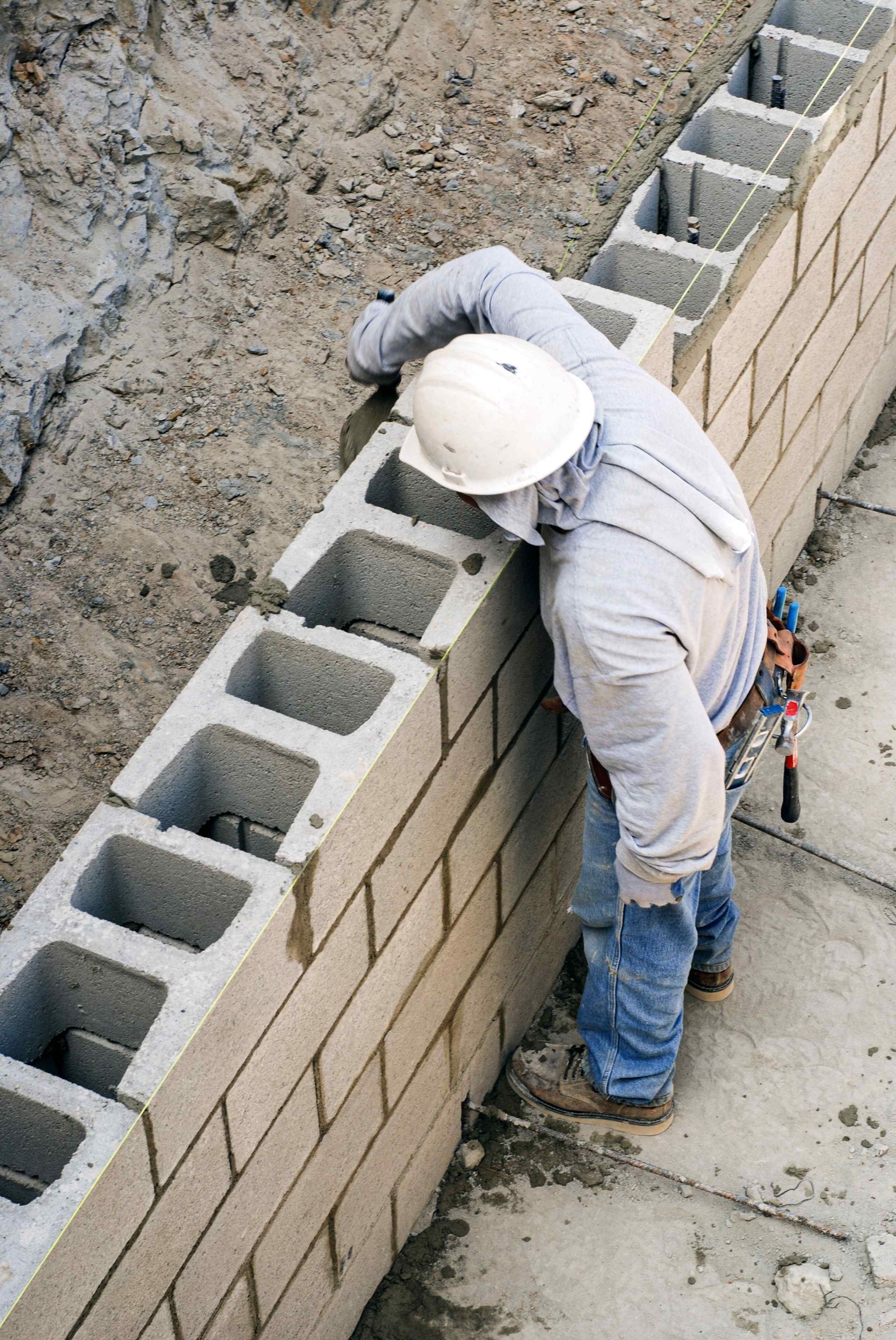 Affordable Landscapes Carson City laborer building a concrete retaining wall