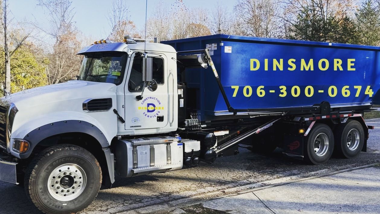 White and blue Dinsmore dump truck with phone number 706-300-0674.