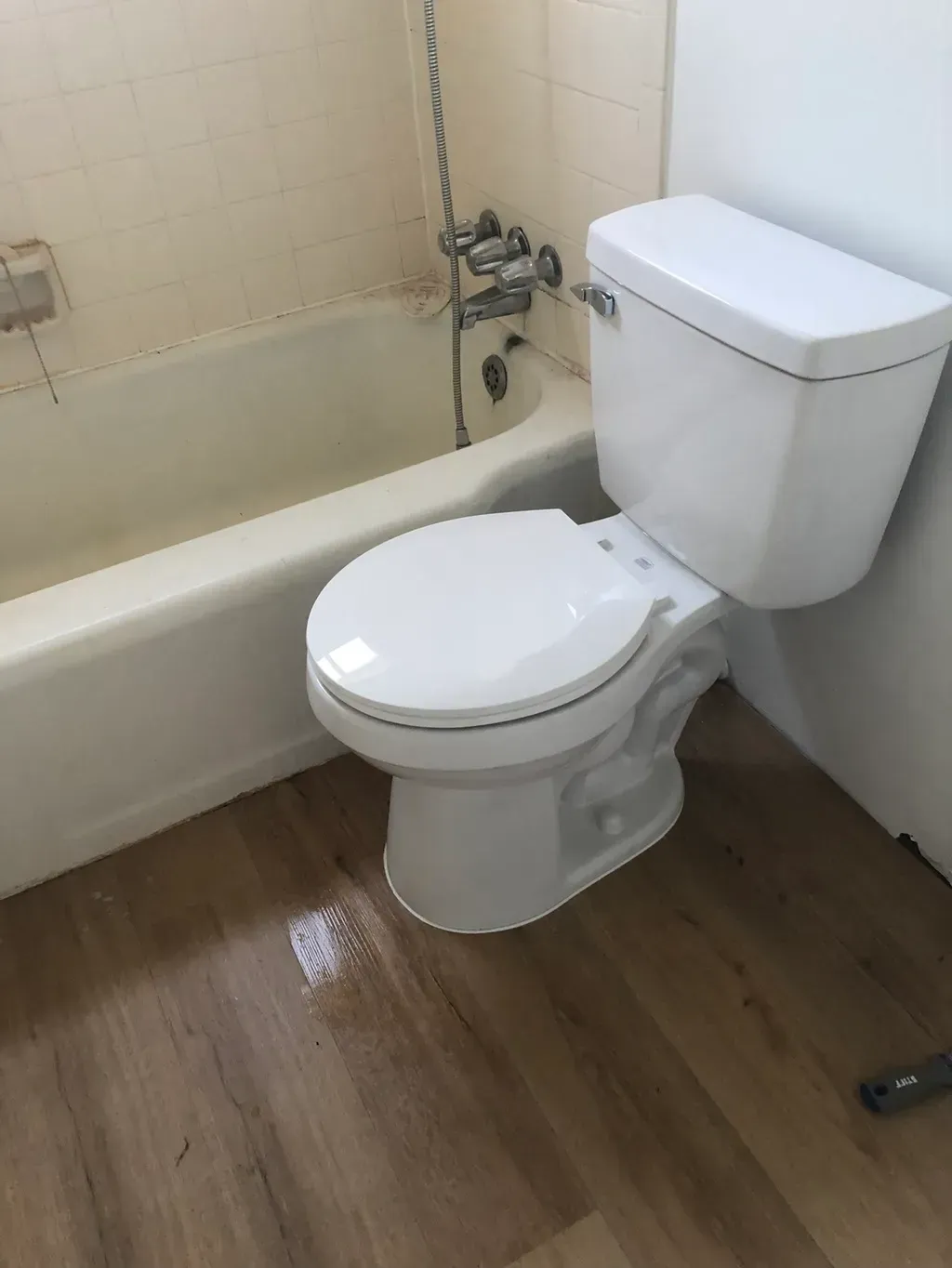 A bathroom with a toilet , bathtub and shower.
