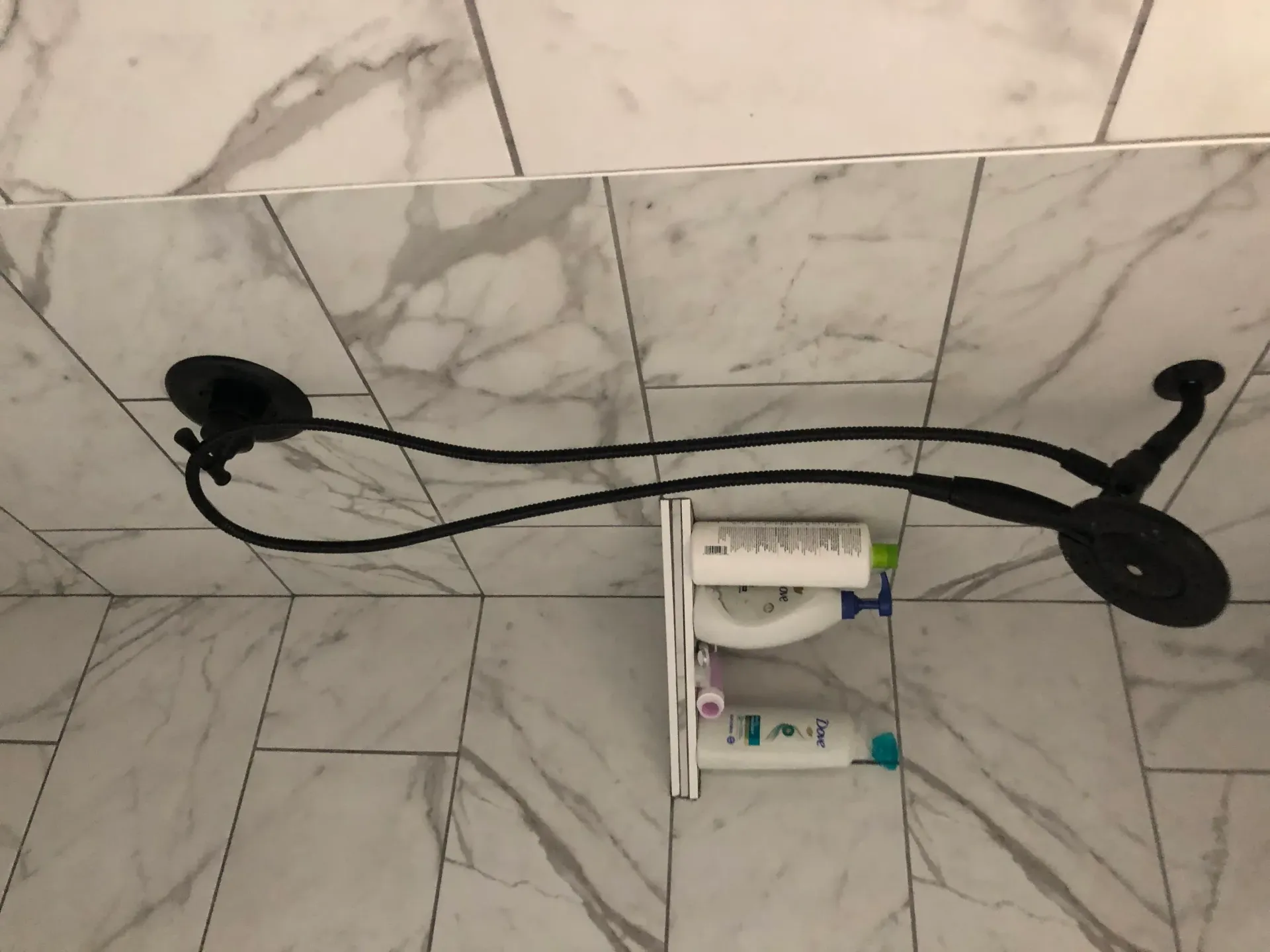 A shower head is hanging from the ceiling in a bathroom