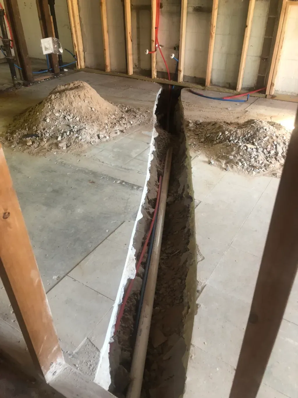 A hole in the floor of a building with a pipe coming out of it.